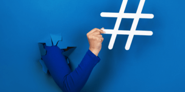 pessoa desenhando hashtag em fundo azul