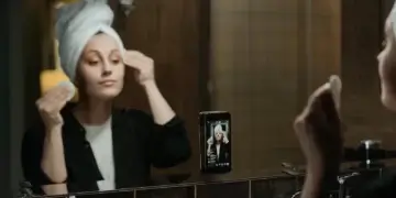 mulher se maquiando em frente ao celular